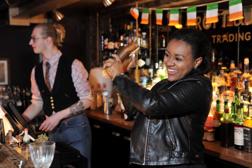 A woman shaking a cocktail in a bar